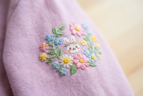 Broderie kawaii lapin et fleurs sur un t-shirt rose
